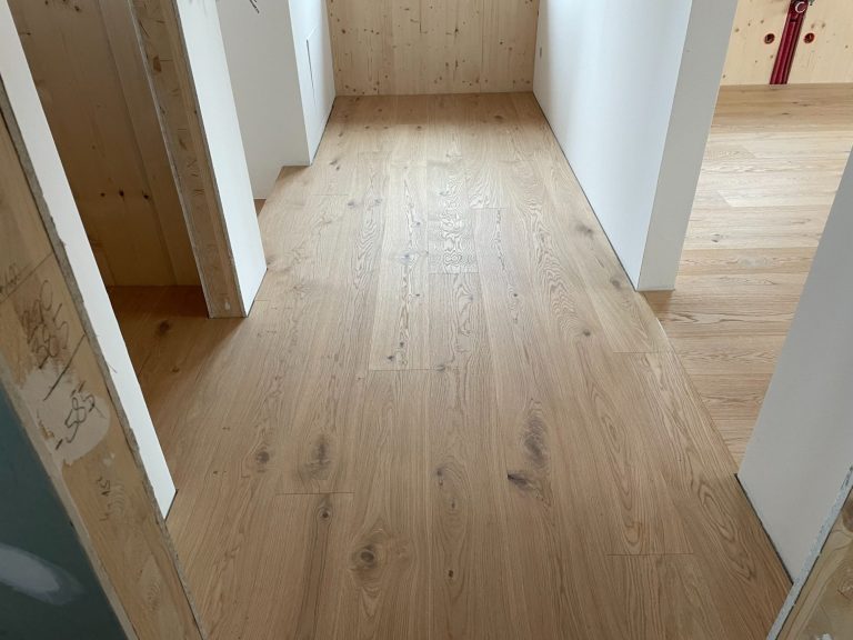 Heller Parkettboden in einem Raum mit Wänden und Türen.