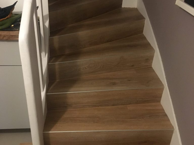Nach oben führende Holztreppe mit weißem Geländer.