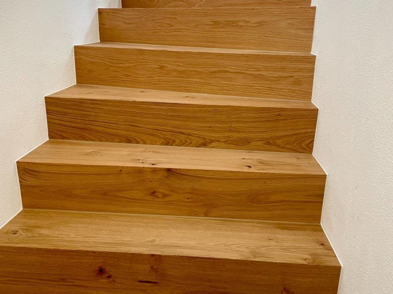 Holztreppe mit mehreren Stufen, die nach oben führen, hellbraune Holzoberfläche.