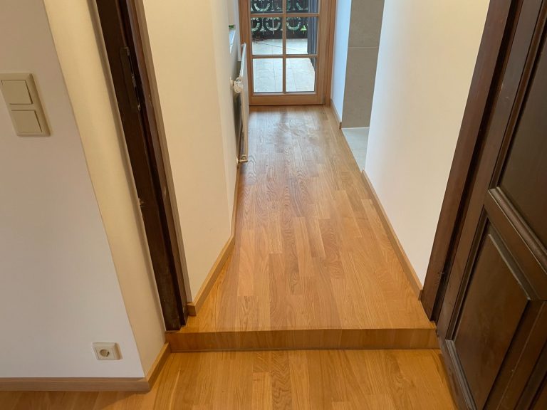 Stabparkettboden im Zugang zu einem Raum mit Fenstertür.
